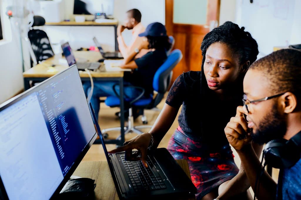 Professionals collaborating at computers in a modern office